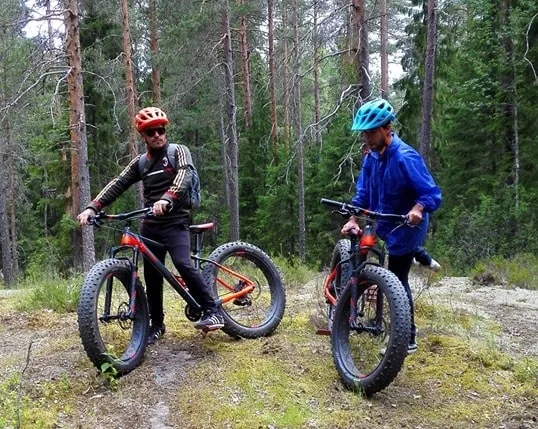 Arja polkupyörällä kurpitsa korissa punainen takki