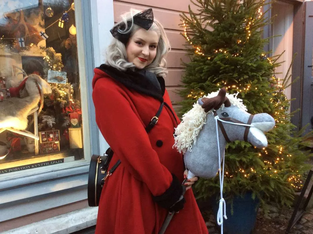 nainen punainen takki keppari keppihevonen joulu